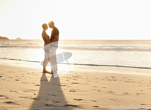 Image of Couple, kiss and beach at sunset for romantic date, weekend getaway and vacation in Mexico. Woman, man or people in love with hug for evening walk, bonding and together in caring happy relationship