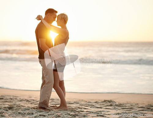 Image of Couple, embrace and romance in sea at sunset to relax, vacation and happy in trip. Partners, together and water in beach to enjoy, calm and smile for love of marriage in honeymoon and holiday