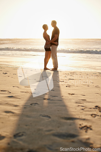 Image of Man, woman and hug at beach for sunset for holiday happiness together, honeymoon or marriage. Couple, evening and embrace for commitment or Miami weekend for love travel, vacation or relationship