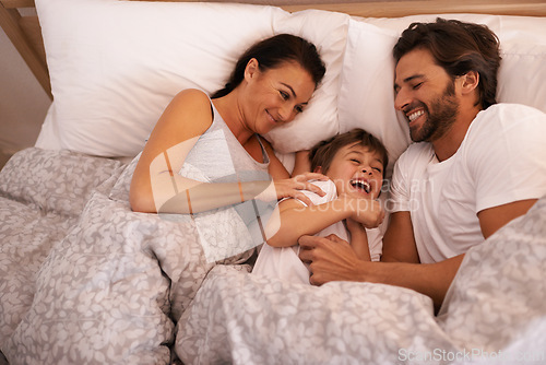 Image of Parents, boy and tickling with laughing in bed for care, bonding or love with joke in family house. Father, mother and child with funny game, excited or happy for comic smile together in home bedroom
