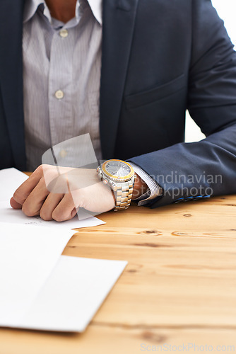 Image of Man, hand and wristwatch on desk with paperwork for information, notes and deadline for task. Closeup, business and suit with time for schedule on appointment to report, update and give feedback.