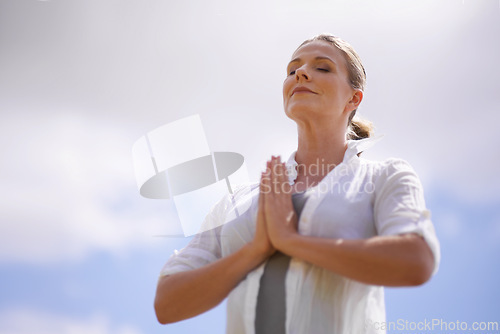 Image of Happy woman, yoga and meditation in spiritual wellness or faith with cloudy sky background. Female person or yogi meditating or hands together for praying, hope or awareness with fresh air in nature