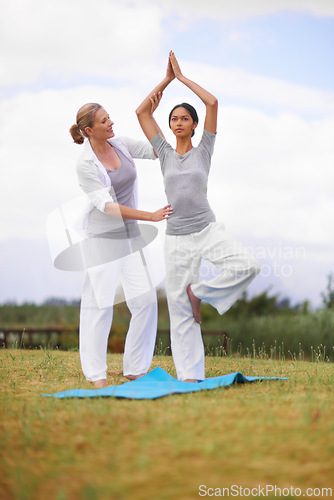 Image of Woman, personal trainer and yoga on field in nature for spiritual wellness, namaste or wellbeing. Young female person, yogi or fitness teacher in zen, balance or stretching on mat in outdoor exercise