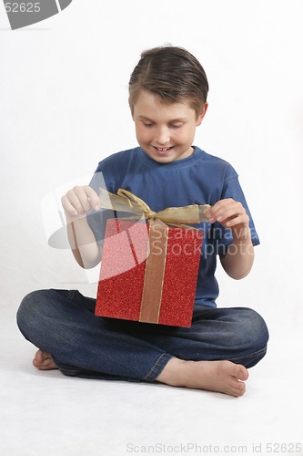 Image of Sitting child opening a present