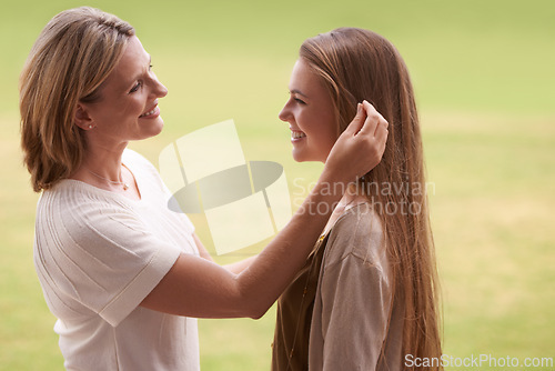 Image of Happy, mother and daughter touching hair for love, care and proud family for support. Woman, smiling and outdoors for healthy relationship, parent and mom with teenage daughter in nature park