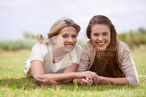 Image of Women, mother and daughter with holding hands, grass and mature person with connection, care and love. Mom, girl and family with bonding, reunion and vacation with lawn, happy and together in spring