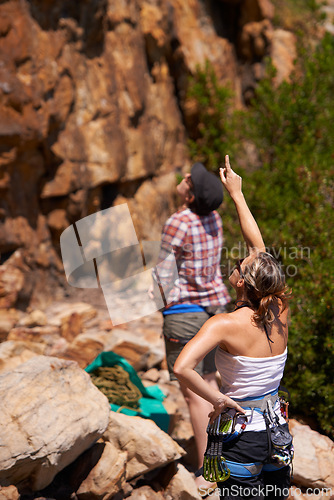 Image of Rock climbing, view and friends with route planning and pointing for adventure and outdoor exercise. Mountain, sport and training in nature with people on a peak for a workout together for fitness