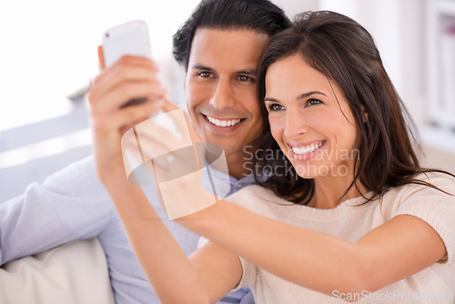 Image of Happy couple, sofa and selfie in relax for photography, picture or bonding memory together in living room at home. Young man or woman with smile for photo, vlog or social media on couch at house