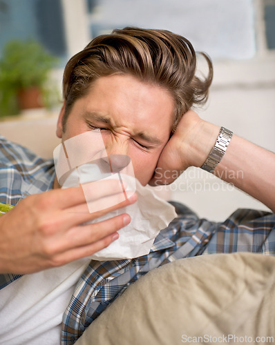 Image of Sick, flu or man sneezing into tissue on sofa with cold, virus or hay fever at home. Influenza, allergies or person with toilet paper for viral infection, bacteria or coughing with sinusitis in house