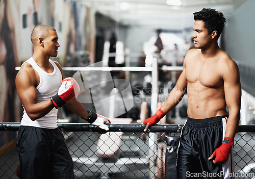 Image of Fitness, talking and fighter in gym with coach for training, self defense or combat training. Exercise, sports or boxing with shirtless man and personal trainer in preparation for competition