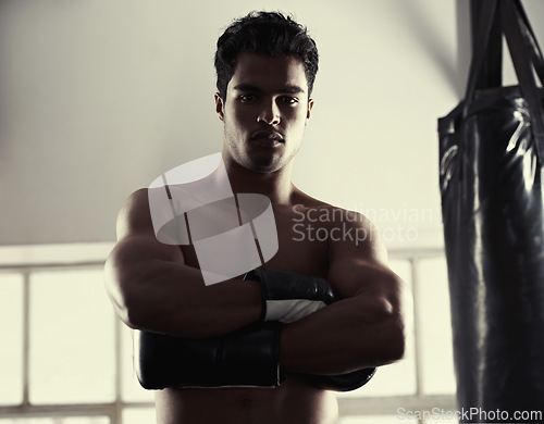 Image of Man, portrait and confident with boxing gloves in gym for combat sport, fitness and competition for strong people. Male fighter, determined and ready for self defense, focus and fit with muscles