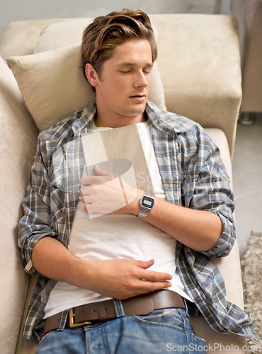 Image of Living room, man and sleep on sofa with book for reading, break and tired at home with fatigue. House, nap and exhausted on couch to rest with dreams for wellness, stress relief, self care and relax