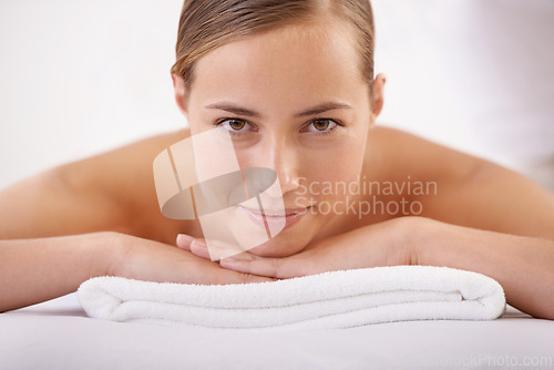 Image of Massage, smile and portrait of woman on table for luxury, treatment and pamper with peace in hotel spa. Female person, bed and resort with body care for cosmetic, wellness and rest on vacation