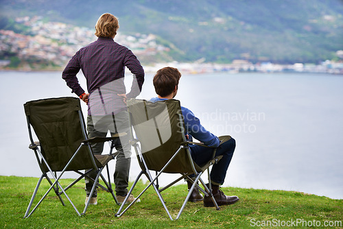 Image of Camping, chair and people relax at lake with landscape in countryside, nature or calm vacation. Summer, holiday and back of friends sitting on grass at river with peace in environment together