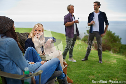 Image of Friends, men and women with drinks for relax on grass in nature with happiness for holiday and vacation. People, smile and alcohol in countryside or lake for adventure, travel and bonding in forest