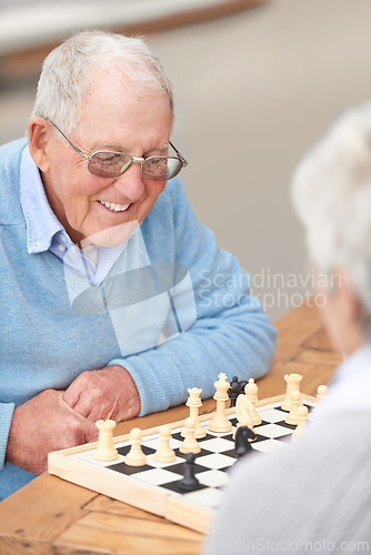 Image of Chess, game and happy outdoor with old people together in retirement to relax on holiday or vacation. Elderly, friends and person smile for winning competition, checkmate or activity with strategy