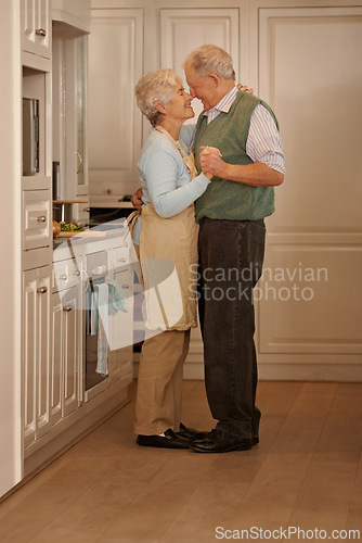 Image of Senior, couple and love with dancing in kitchen for bonding, support and holding hands while cooking. Elderly, man and woman with hug, embrace and smile for relationship, dancer or happiness in home