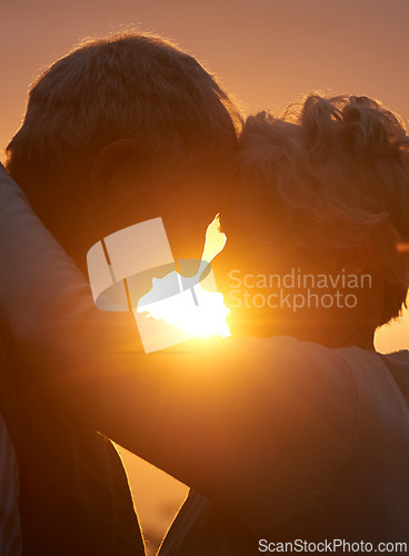 Image of Sunset, senior couple and embrace outdoor, care and bonding for connection together in nature. Man, woman and touch forehead for love, romance and hug for commitment to relationship in retirement