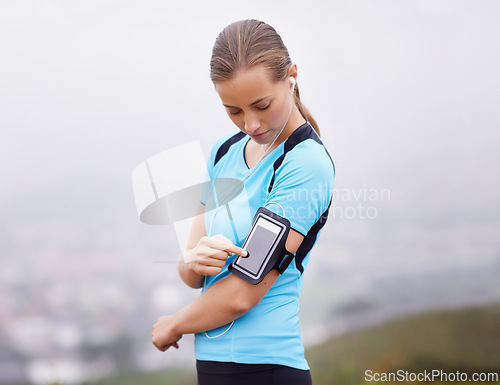 Image of Fitness, phone and music with runner woman outdoor in mountains for health or cardio workout. Exercise, running and training with young athlete in nature or countryside for physical improvement