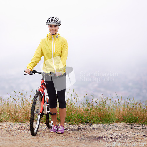 Image of Portrait, smile and woman with bike in mountains for morning exercise, training or off road hobby. Cycling, fitness and sports with happy young athlete in countryside or nature for workout ride