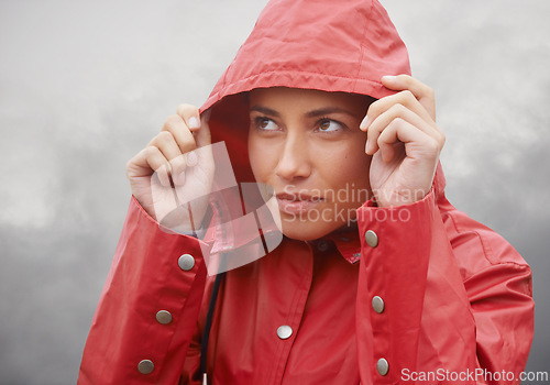 Image of Woman, rain jacket and hood with weather for cloudy sky, winter season or outdoor storm. Face of female person with red waterproof coat and looking up at rainy overcast for cold, protection or fog