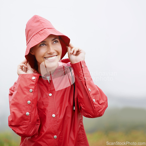 Image of Woman, smile and raincoat for protection, outdoor nature and waterproof jacket for rain or weather. Female person, happy and safety or shield from cold, winter and travel to Scotland for holiday