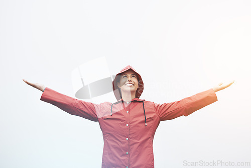 Image of Happy woman, rain jacket and freedom with hood for weather, cloudy sky or winter season in outdoor storm. Female person with smile in red waterproof raincoat for overcast, fog or snow on mockup space