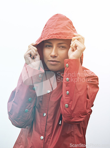 Image of Woman, portrait and rain jacket with hood for weather, cloudy sky or winter season in outdoor storm. Face of female person or young model with red waterproof raincoat for rainy overcast, fog or snow