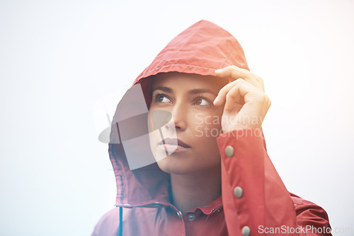 Image of Woman, rain jacket and thinking with hood for weather, cloudy sky or winter season in outdoor storm. Face of female person with red waterproof coat in wonder for rainy overcast or fog on mockup space