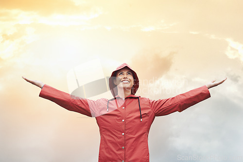 Image of Happy woman, raincoat and freedom with weather for cloudy sky, sun or winter season in outdoor storm. Female person with smile in red waterproof rain jacket for overcast, fog or snow on mockup space