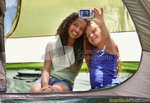 Image of Happy girl, friends and selfie in tent for memory, camping or photography together with camera. Young female person, child or kids with smile for picture, photo or social media in relax or friendship
