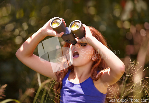 Image of Little girl, binoculars and nature for sightseeing, explore or outdoor vision in the woods. Young female person, child or teenager enjoying sight, adventure or bird watching and search in forest