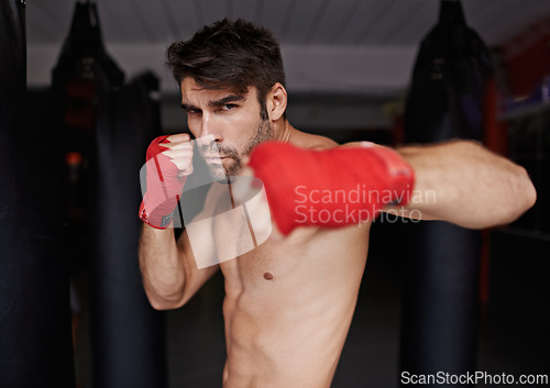 Image of Man, portrait and ready for boxing or fight, fitness and topless for exercise and workout. Male person, bodybuilder and punching bag for challenge or practice, training and serious for competition