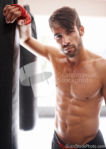 Image of Man, portrait and ready for boxing in gym, fitness and topless for exercise and workout. Male person, bodybuilder and punching bag for challenge or practice, training and serious face for competition