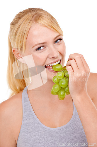 Image of Studio, woman and portrait with eating grapes for vitamin c, vegan and diet for wellness. Food, face and happy person with fruit for detox, gut health and nutrition benefits on white background