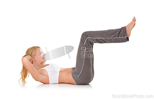 Image of Woman, yoga and sit ups on floor in studio for exercise, healthy body or wellness with fitness, smile or flexibility. Pilates, person and warm up with sportswear for core strength on white background