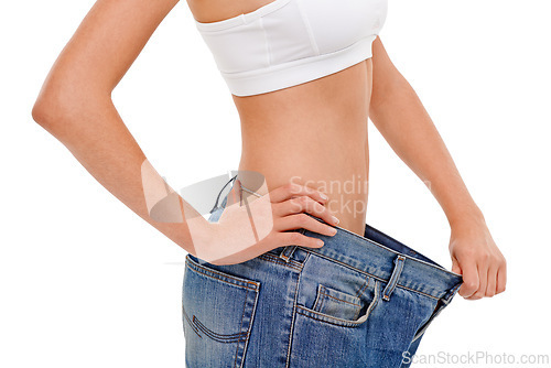 Image of Diet, health and woman with big pants in studio for weight loss, fitness or exercise results. Wellness, body and closeup of female person with jeans for measuring slim stomach by white background.