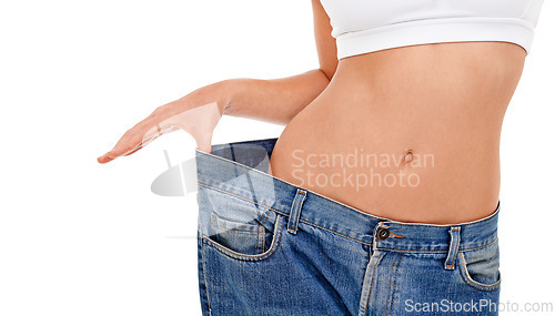 Image of Body, health and woman with big pants in studio for weight loss, fitness or exercise results. Wellness, diet and closeup of female person with jeans for measuring slim stomach by white background.