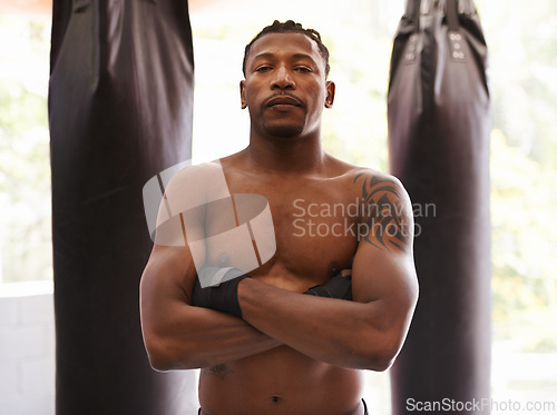 Image of Fitness, boxing and portrait of black man in gym for challenge, arms crossed and competition training. Power, muscle and serious face of champion boxer at workout with confidence in sports club.