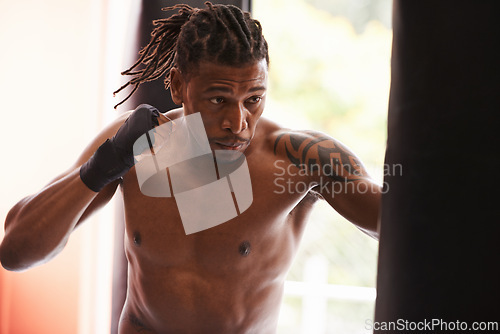 Image of Fitness, punching bag and black man in gym for fight, exercise or boxing competition training. Power, muscle and serious champion boxer at workout with confidence, challenge and energy in sports club