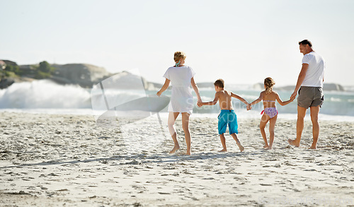 Image of Parents, children and hand holding on beach for travel together at ocean for trip connection, bonding or love. Man, woman and siblings with back view at sea in Florida for vacation, outdoor or family