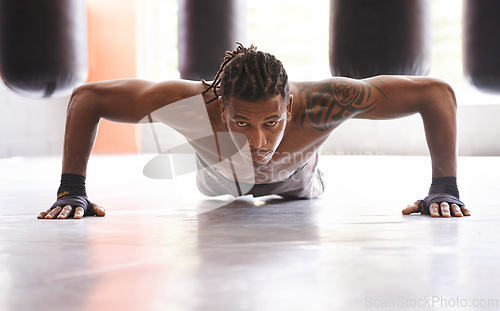 Image of Portrait, exercise and push up with black man on floor of gym for training strong muscles or power. Fitness, health and body with confident young athlete in workout to improve physical wellness