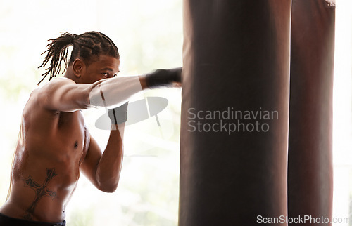 Image of Workout, punching bag and black man boxing in gym for exercise, sports challenge or competition training. Power, muscle and champion boxer at workout with confidence, fight and energy in fitness club