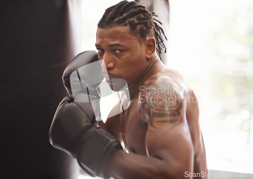 Image of Challenge, portrait and black man with boxing gloves in gym for fitness, fight and competition training. Power, muscle and serious face of champion boxer at workout with confidence in sports club.