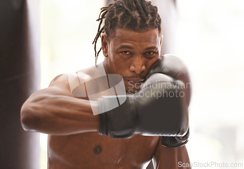 Image of Power, portrait and black man with boxing gloves in gym for challenge, fight and competition training. Fitness, muscle and serious face of champion boxer at workout with confidence in sports club.