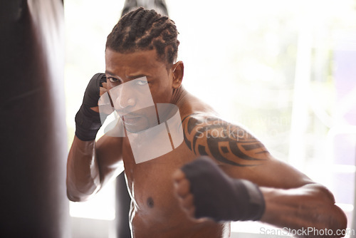 Image of Boxing, portrait and black man with punch in gym for fitness challenge, fight and competition training. Power, muscle and serious face of champion boxer at workout with confidence in sports club.