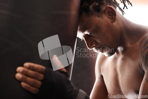 Image of Boxing, fatigue and black man with punching bag in gym for challenge, fight and competition training. Power, muscle and exhausted champion boxer at workout with tired face, thinking and sports club.