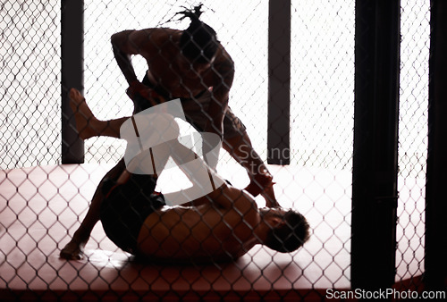 Image of Cage, fight and men sparring for competition, challenge and fitness in mixed martial arts action. Battle, kick boxing and warrior exercise in sports, wrestling and power in match together in gym.