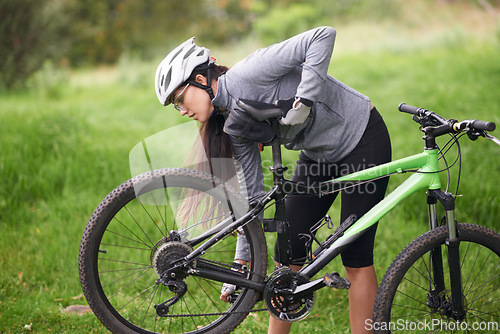 Image of Fitness, bike and flat wheel with woman cyclist in countryside for sports, hobby or cardio training. Exercise, cycling or tyre puncture with young athlete fixing bicycle outdoor in nature for workout