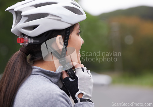 Image of Cycling, woman and fasten helmet for safety, protection and exercise gear to travel outdoor. Bicyclist, person and putting on hat in preparation for training, sports or closeup for fitness in profile